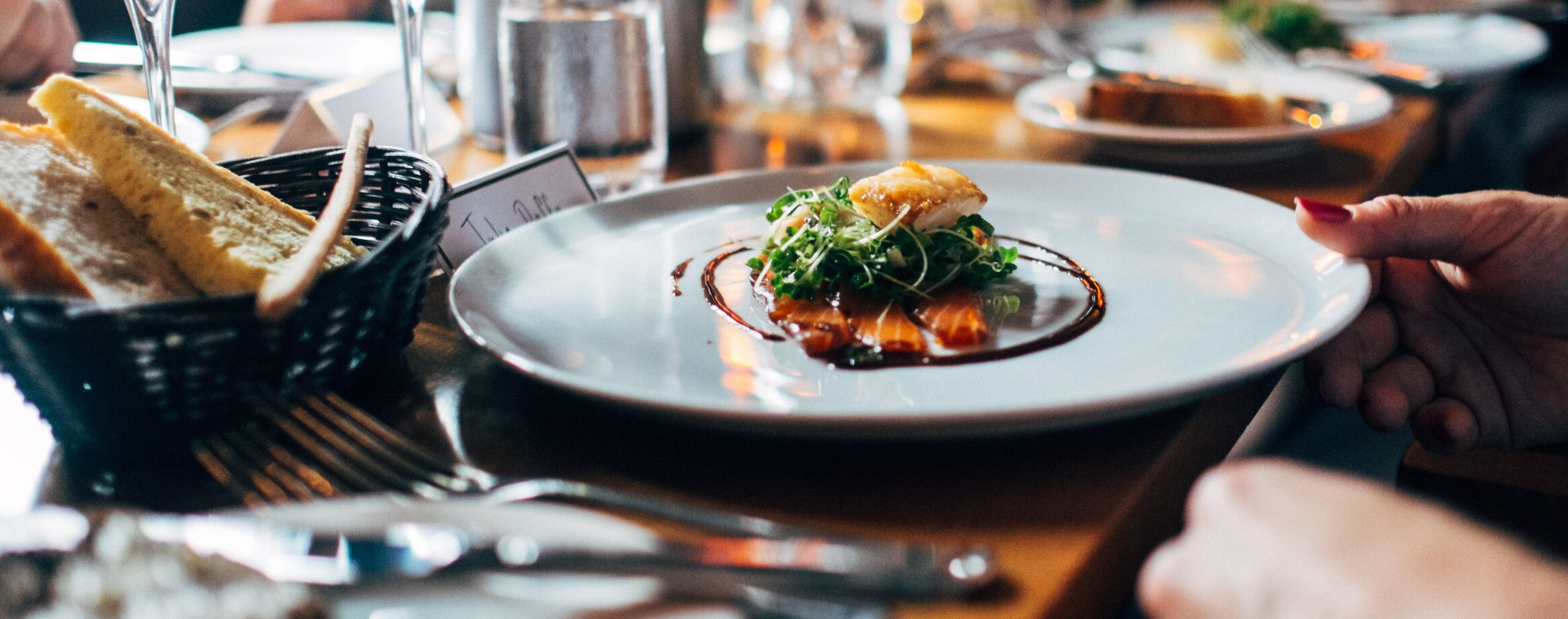 A person is holding a plate of food on a table.