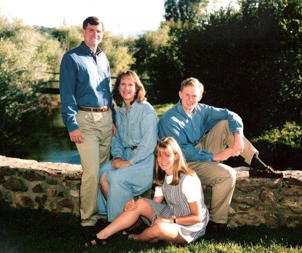 A family posing for a picture in front of a stone wall