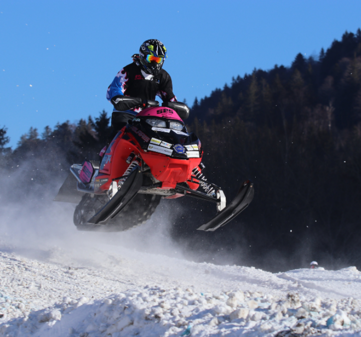 A man is riding a snowmobile with the word hps on the front