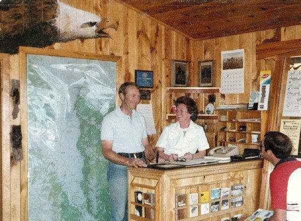 A man and a woman are standing at a counter in front of a map