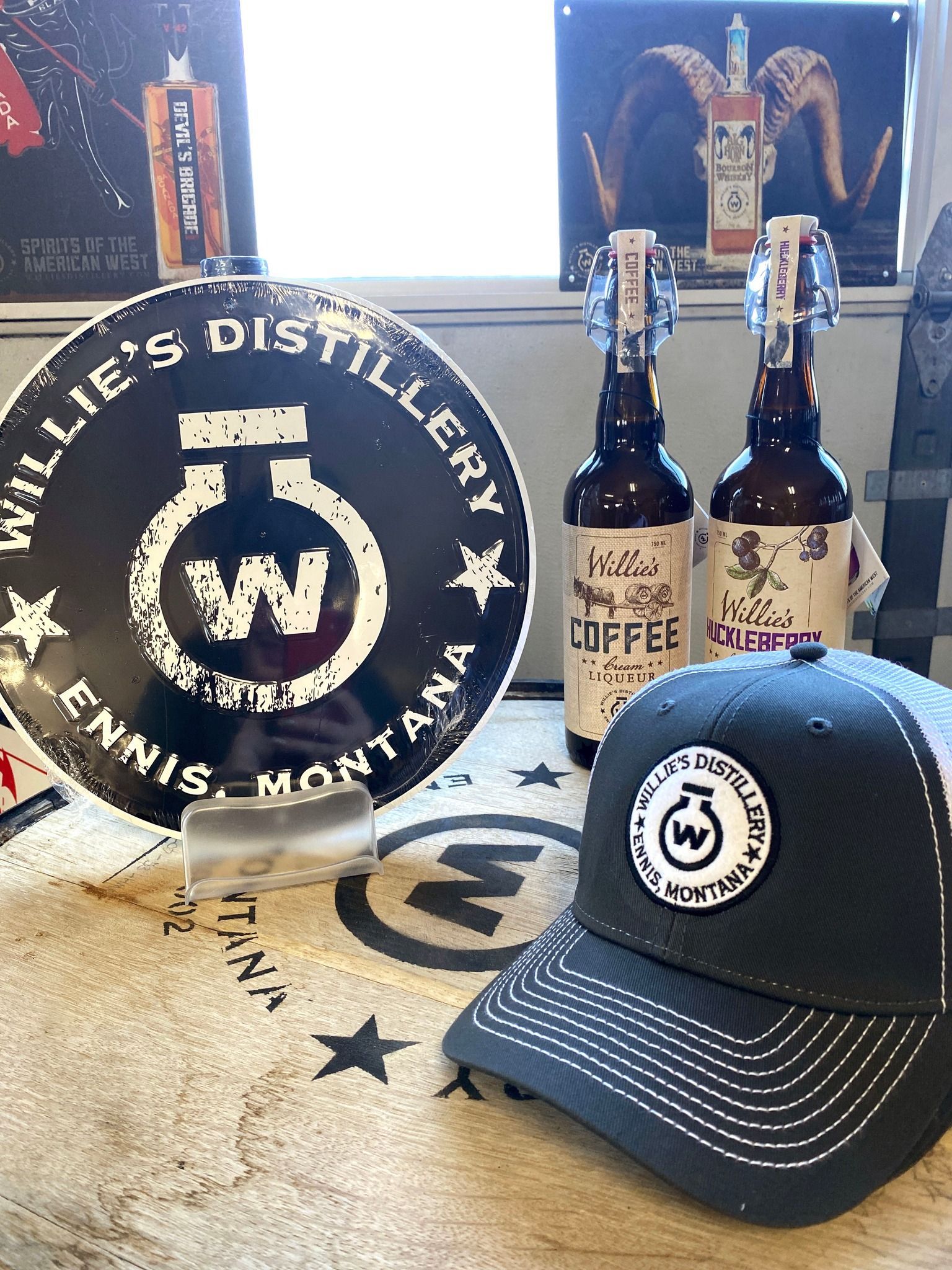 A baseball cap and two bottles of beer are on a table.