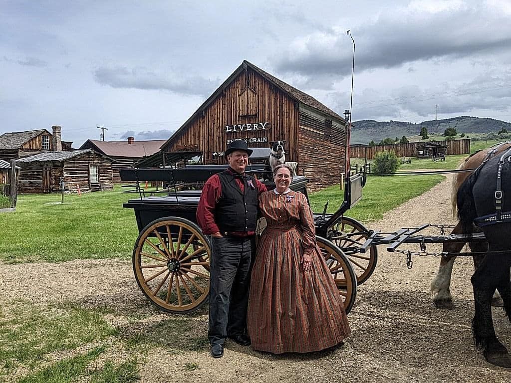 A man and a woman are standing next to a horse drawn carriage.