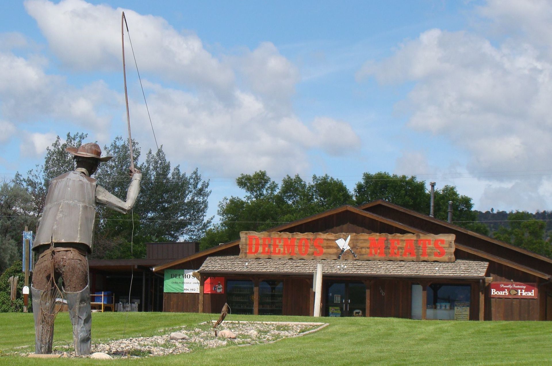 A statue of a man fishing in front of a building that says burger king