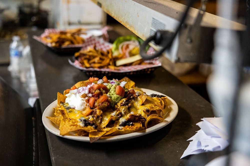 A plate of nachos and french fries on a counter.