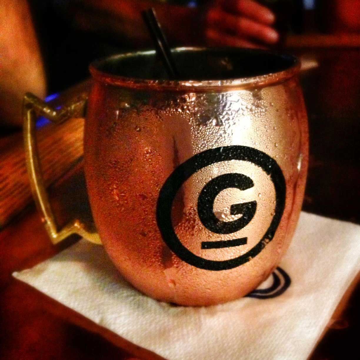 A copper mug with the letter g on it