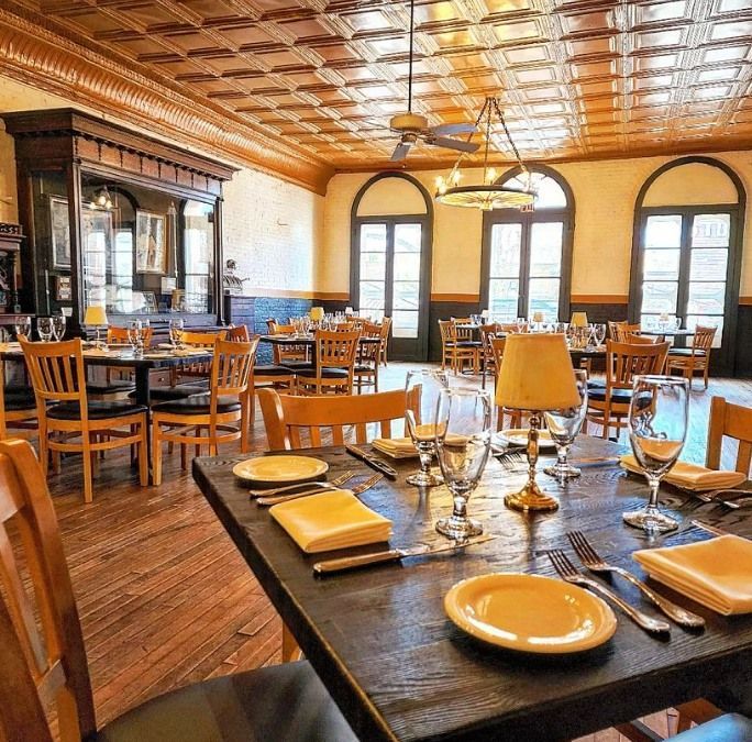 A restaurant filled with tables and chairs with plates and glasses on them