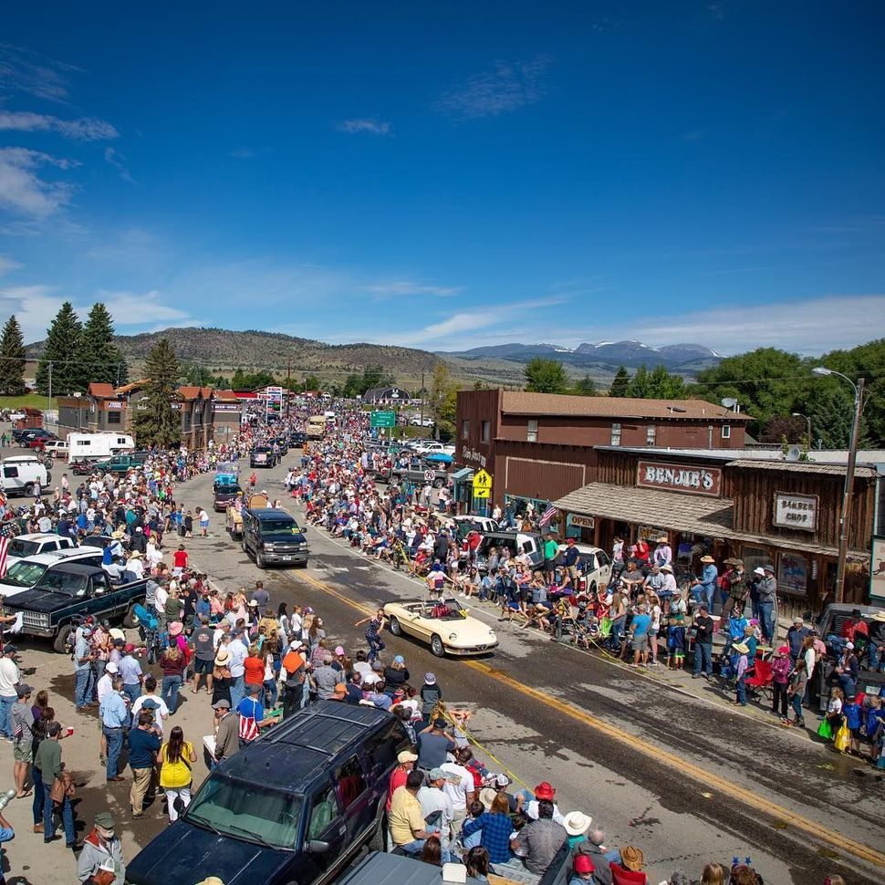 An aerial view of a crowd of people gathered on the side of a street.