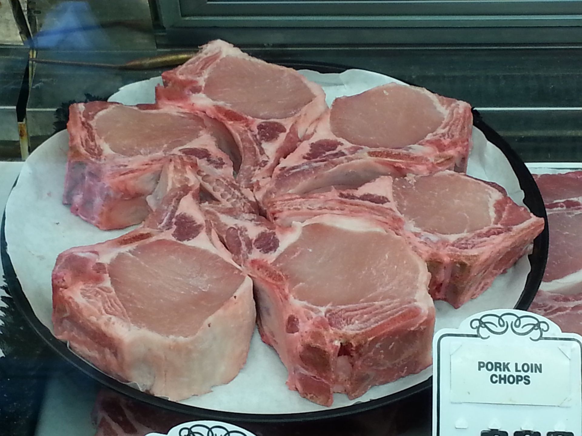 A plate of pork chops with a sign that says pork low chops