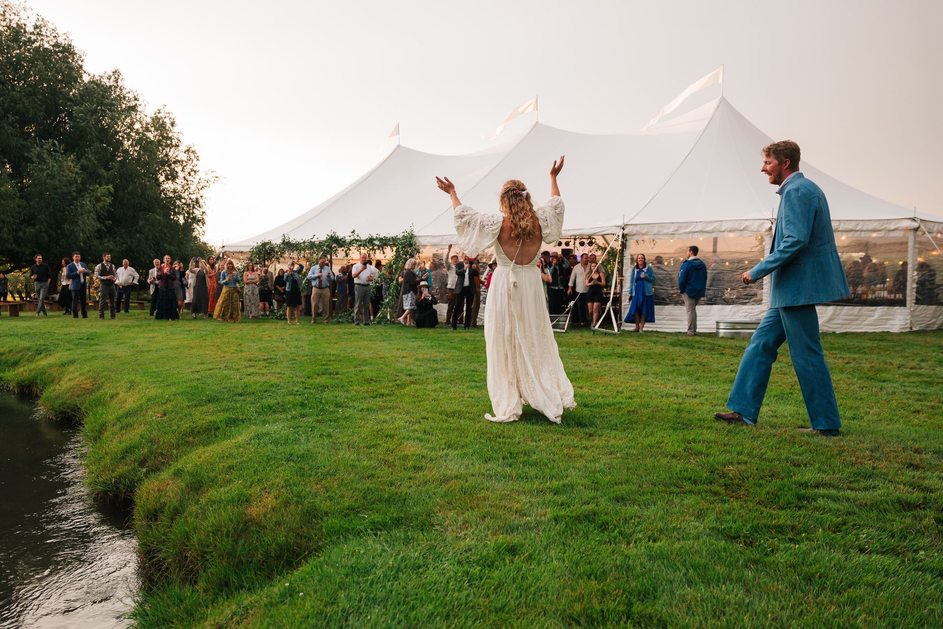 bride and groom near creek in outdoor venue