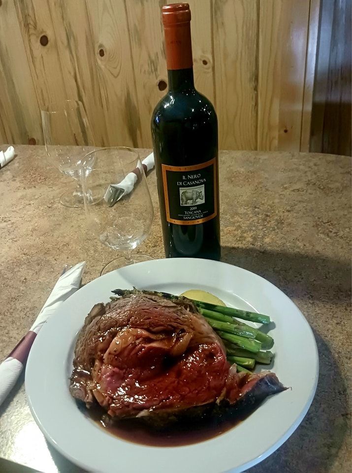 A bottle of wine sits next to a plate of food