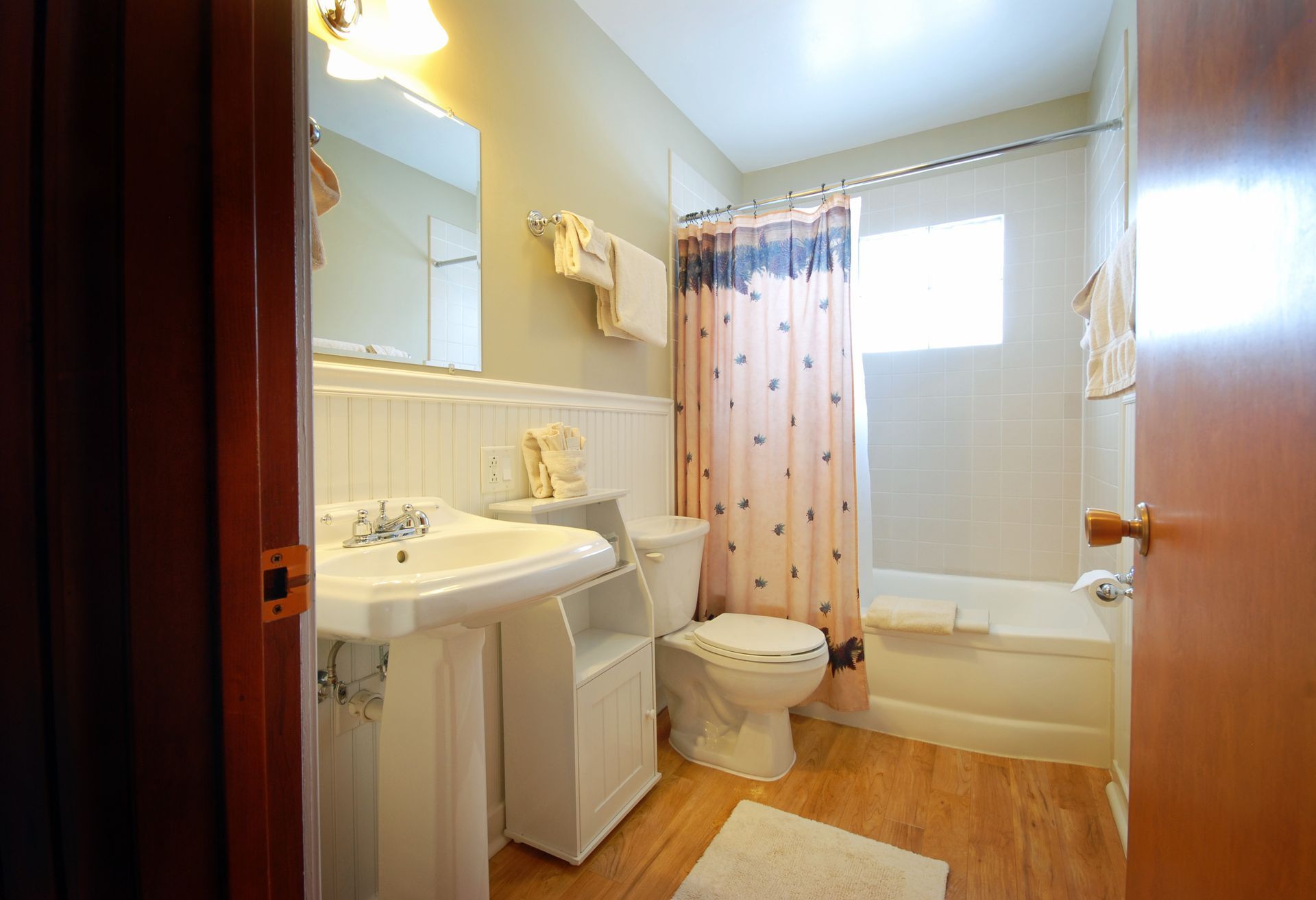 A bathroom with a sink , toilet , bathtub and shower curtain.