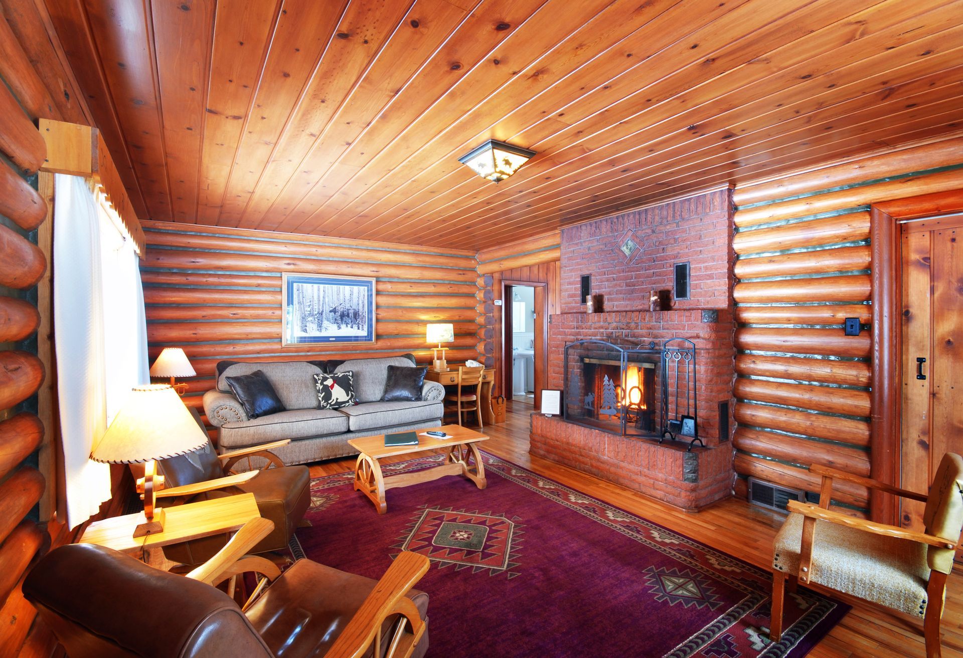 A living room in a log cabin with a fireplace and a couch