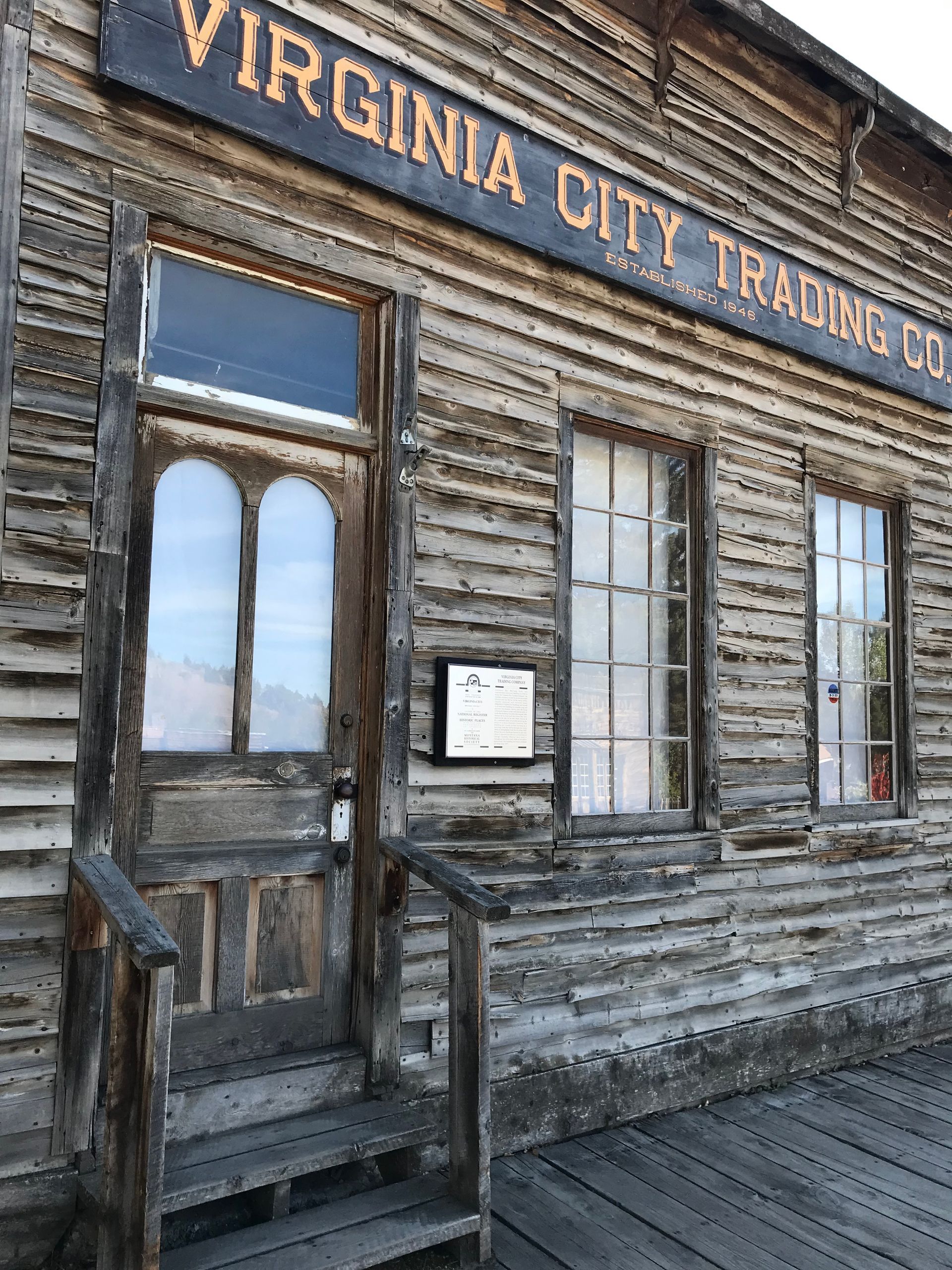 A wooden building with a sign that says `` virginia city trading co. ''