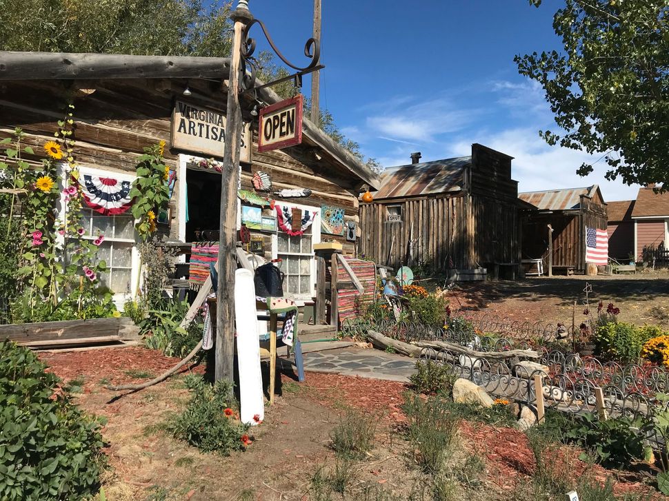 A wooden building with a sign that says open on it