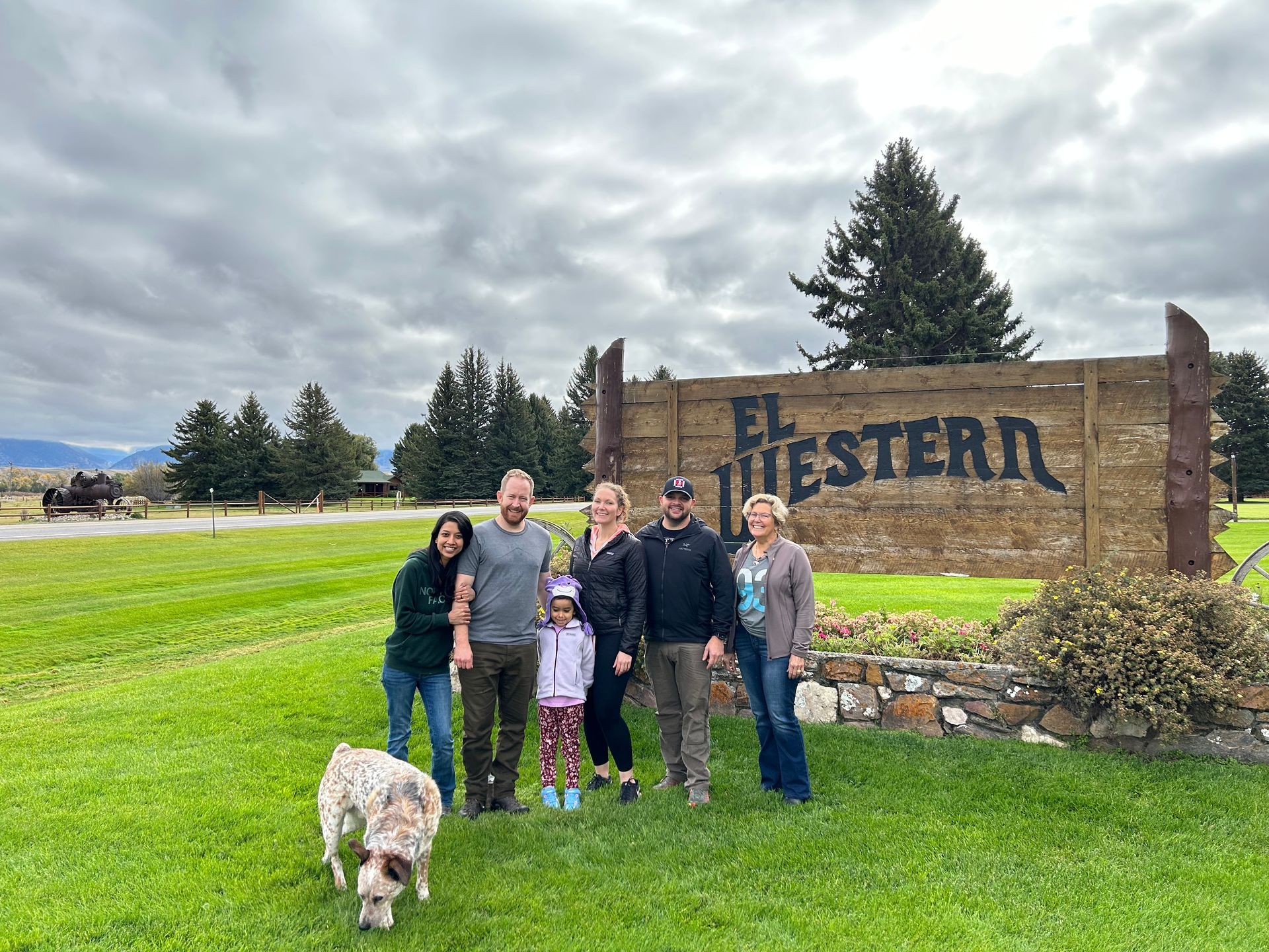 A group of people are posing for a picture in front of a sign.