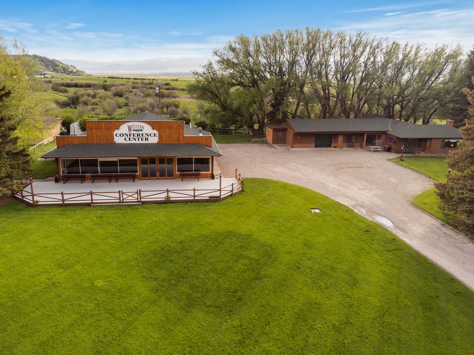 An aerial view of a house in the middle of a grassy field.