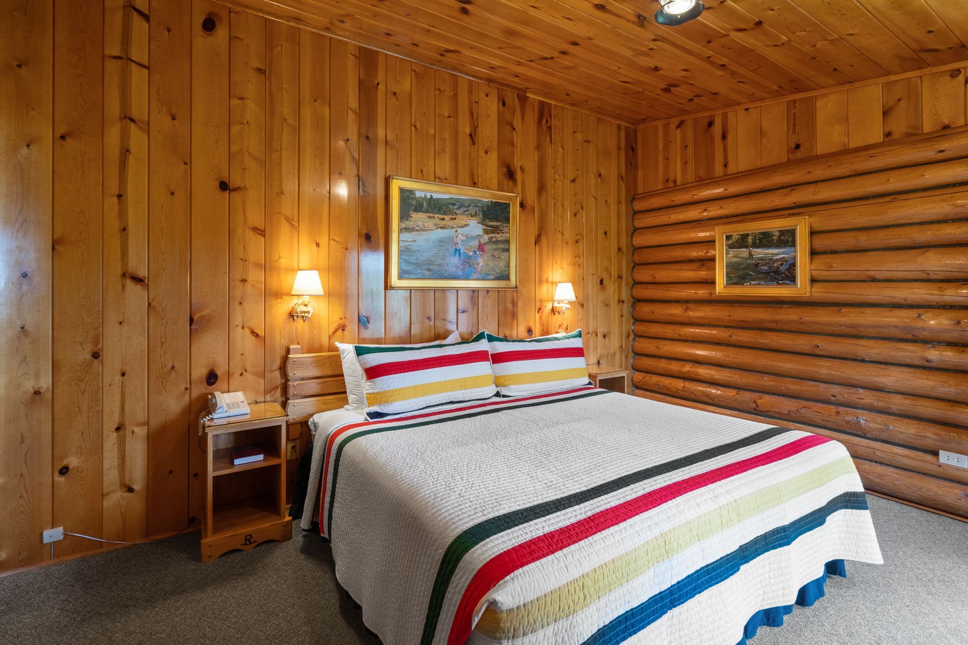 A bedroom in a log cabin with a king size bed.