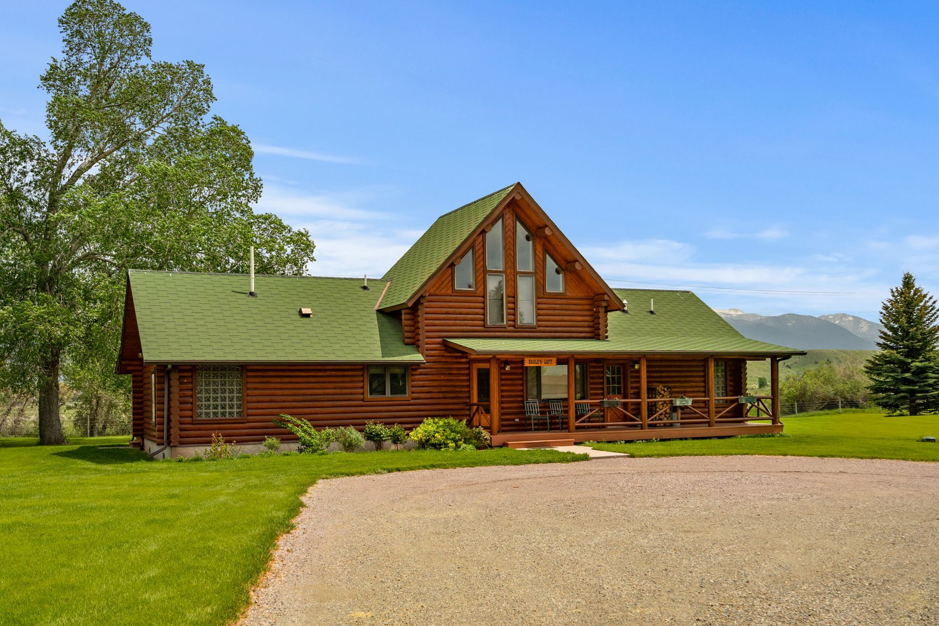 A large log cabin with a green roof