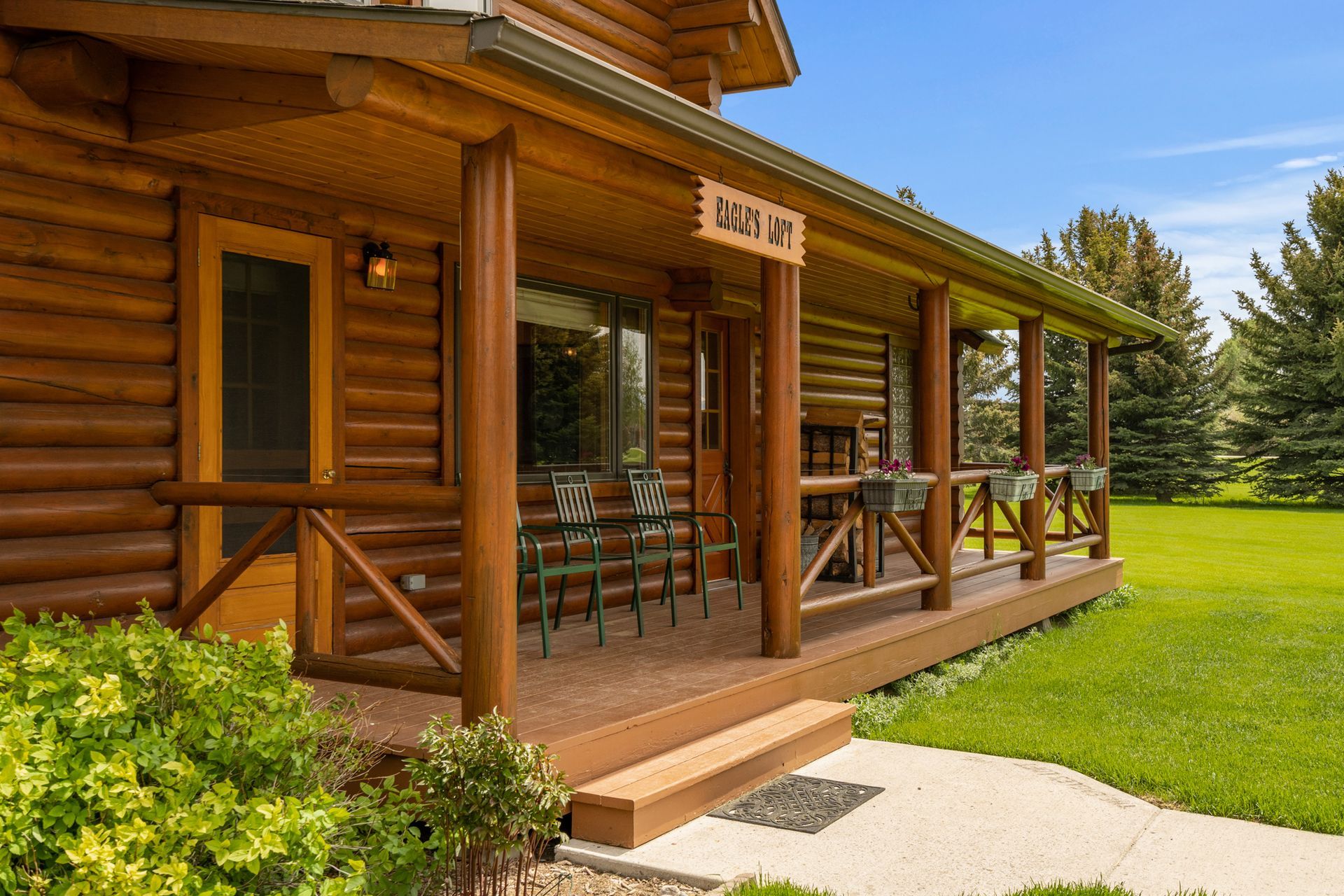 A log cabin with a large porch and stairs leading up to it.