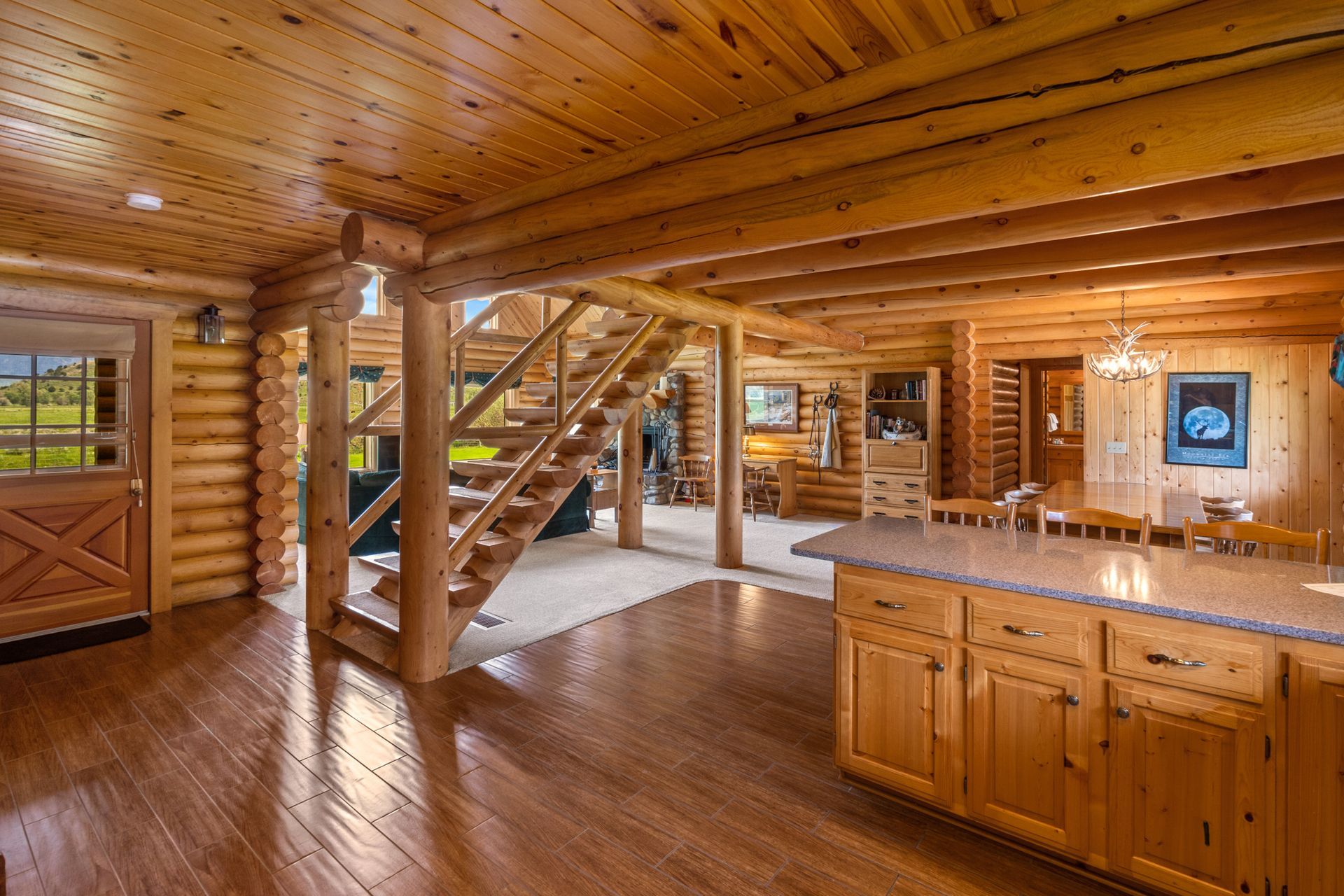 The inside of a log cabin with a kitchen and stairs.