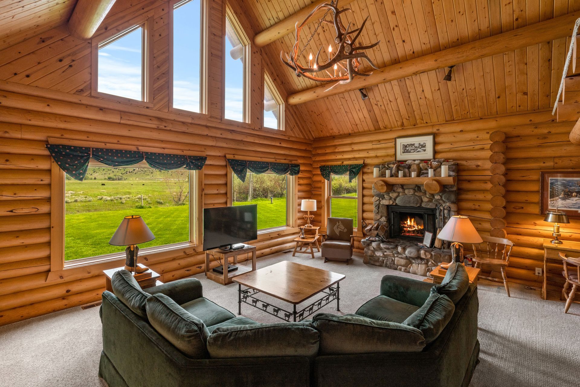 A living room in a log cabin with a fireplace and a couch.