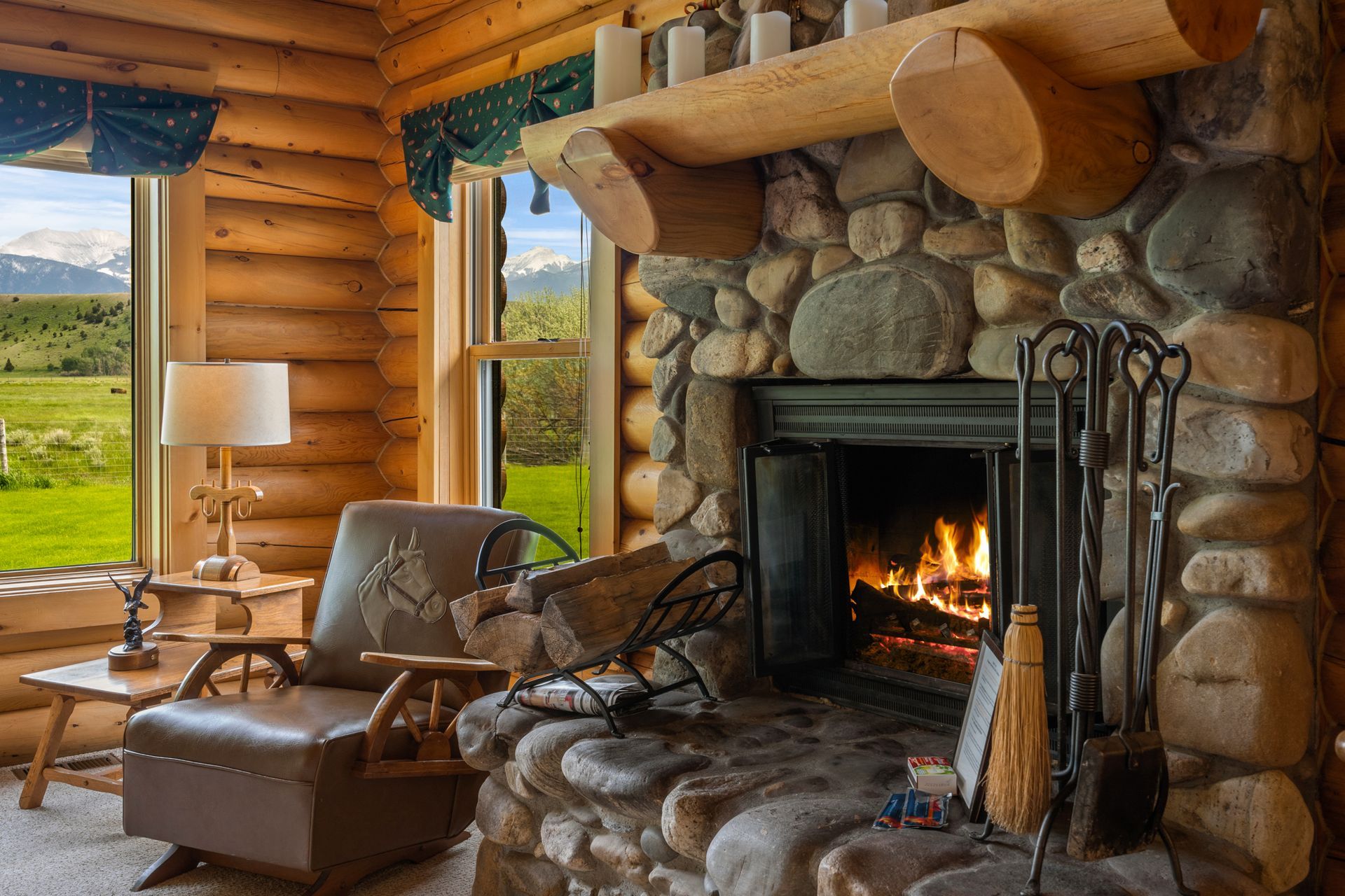 A living room in a log cabin with a fireplace and a chair.