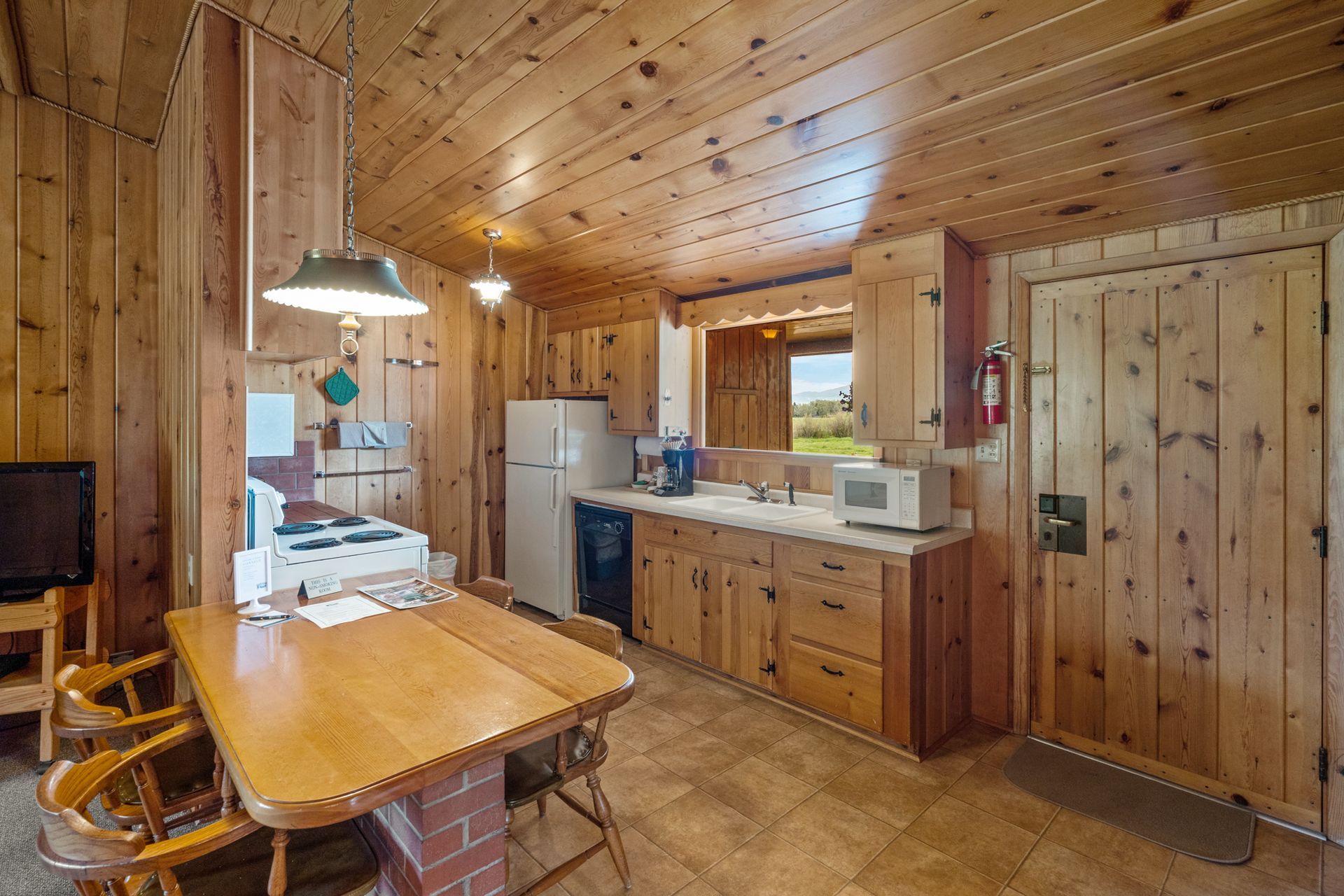 A kitchen in a cabin with a table and chairs.