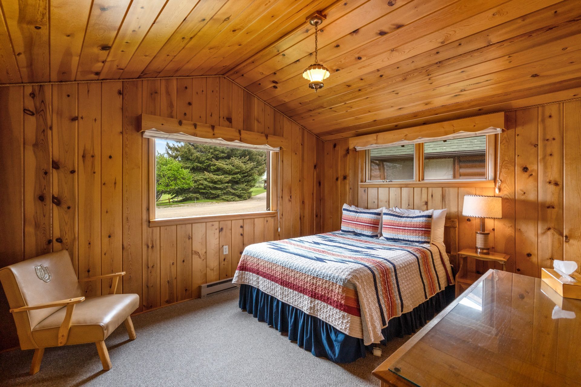 A bedroom with a bed , chair , desk and window.