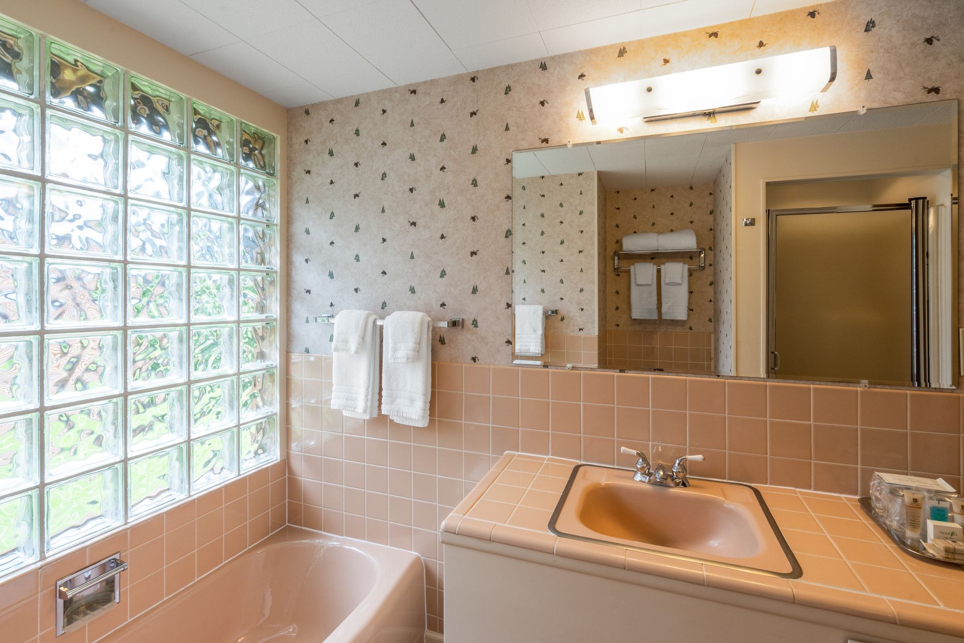 A bathroom with a tub , sink and mirror.