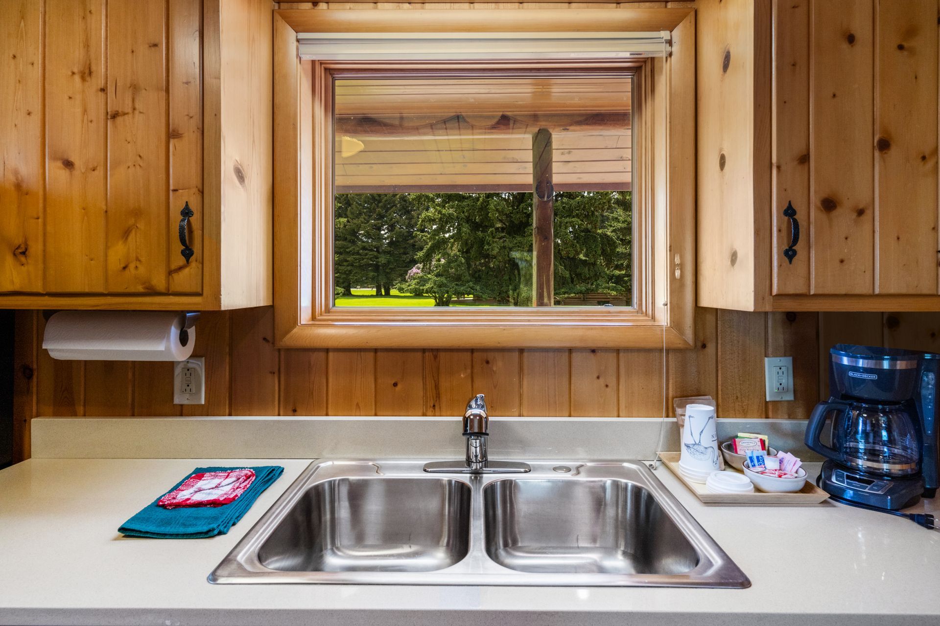 A kitchen with a stainless steel sink and a window.