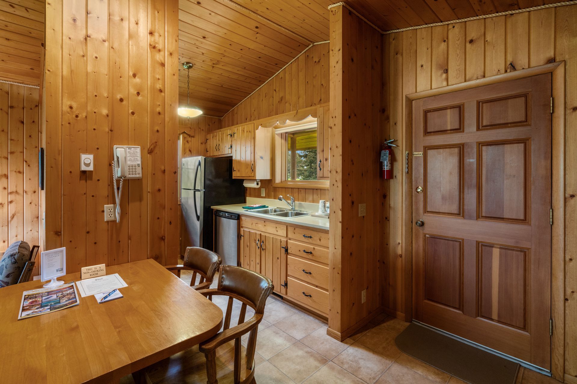 A kitchen with a table and chairs and a refrigerator