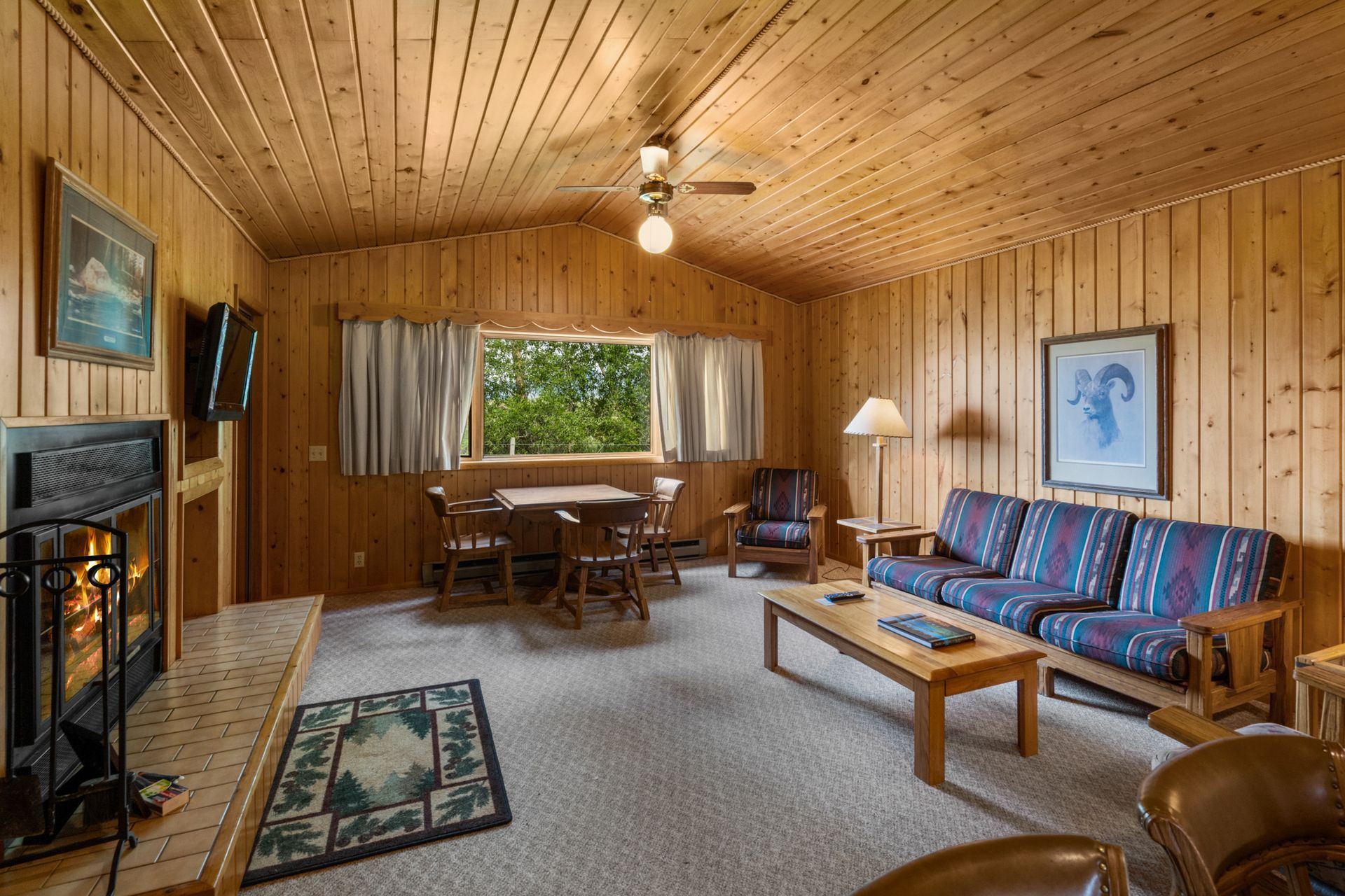 A living room with a couch , table , chairs and fireplace.