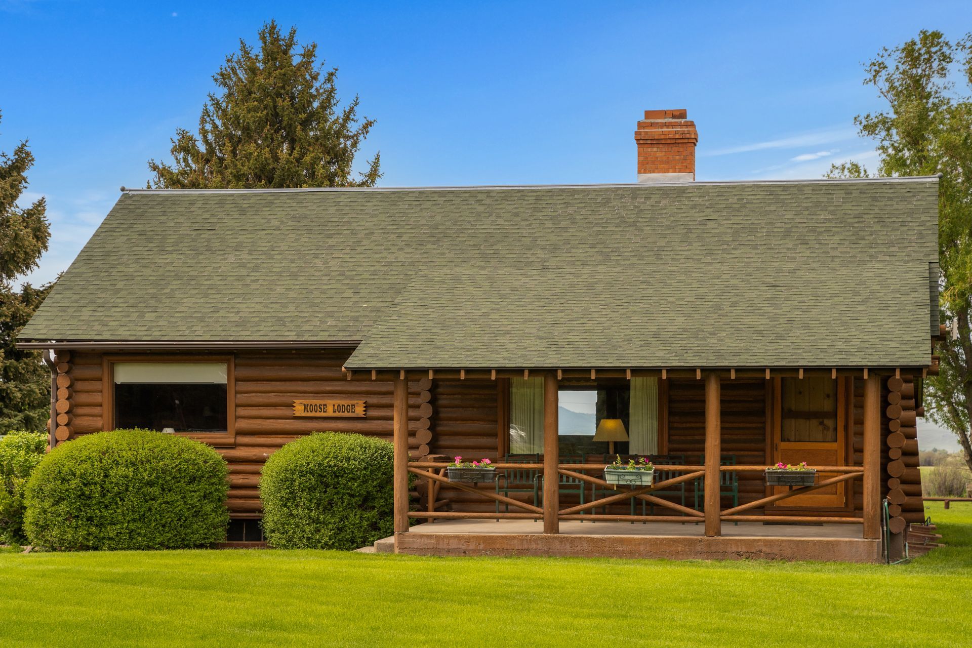 A small log cabin with a porch and a chimney