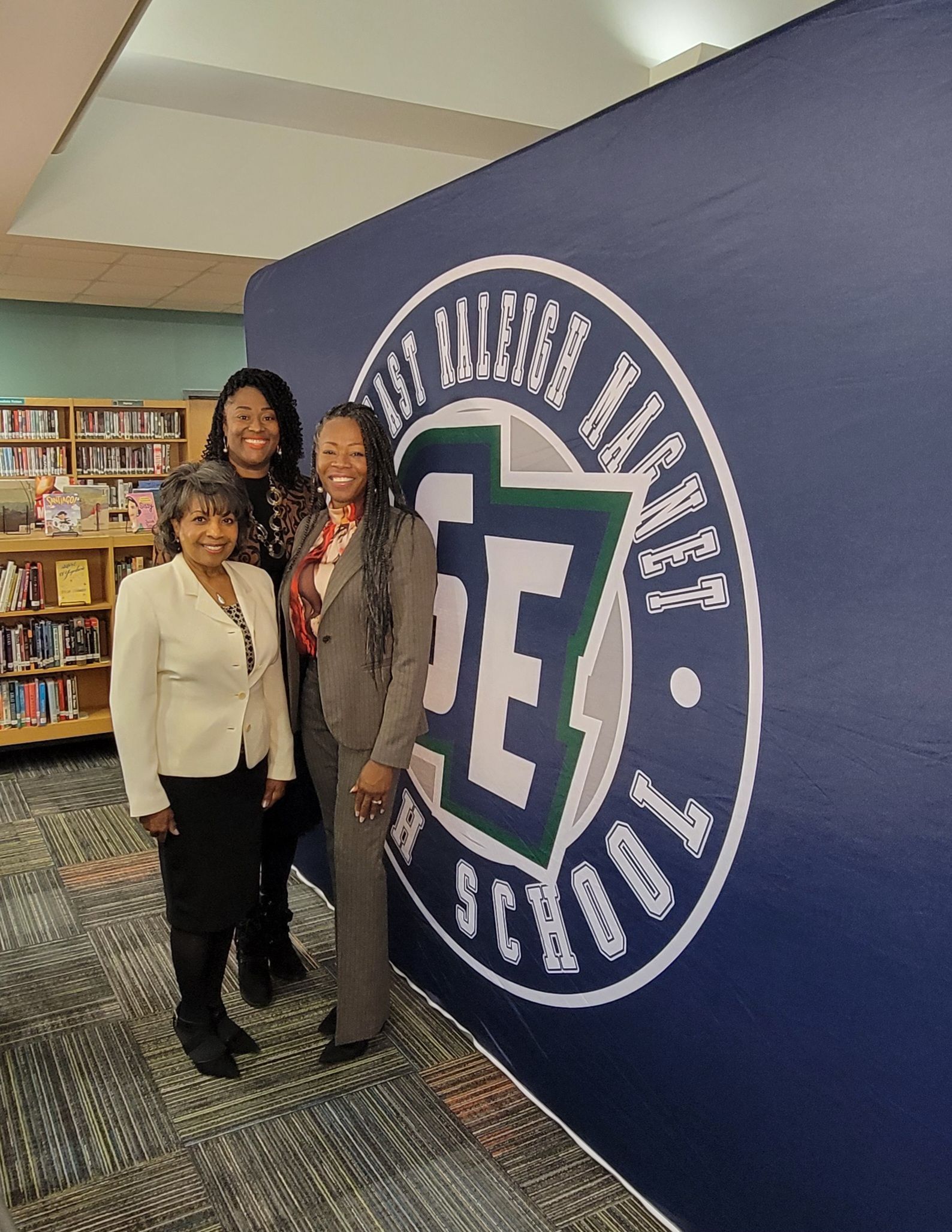 MiMi K and friends are standing in front of a wall with a te logo on it