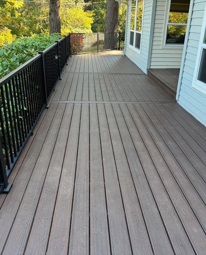A wooden deck with a metal railing leading to a house A wooden deck with a metal railing leading to a house