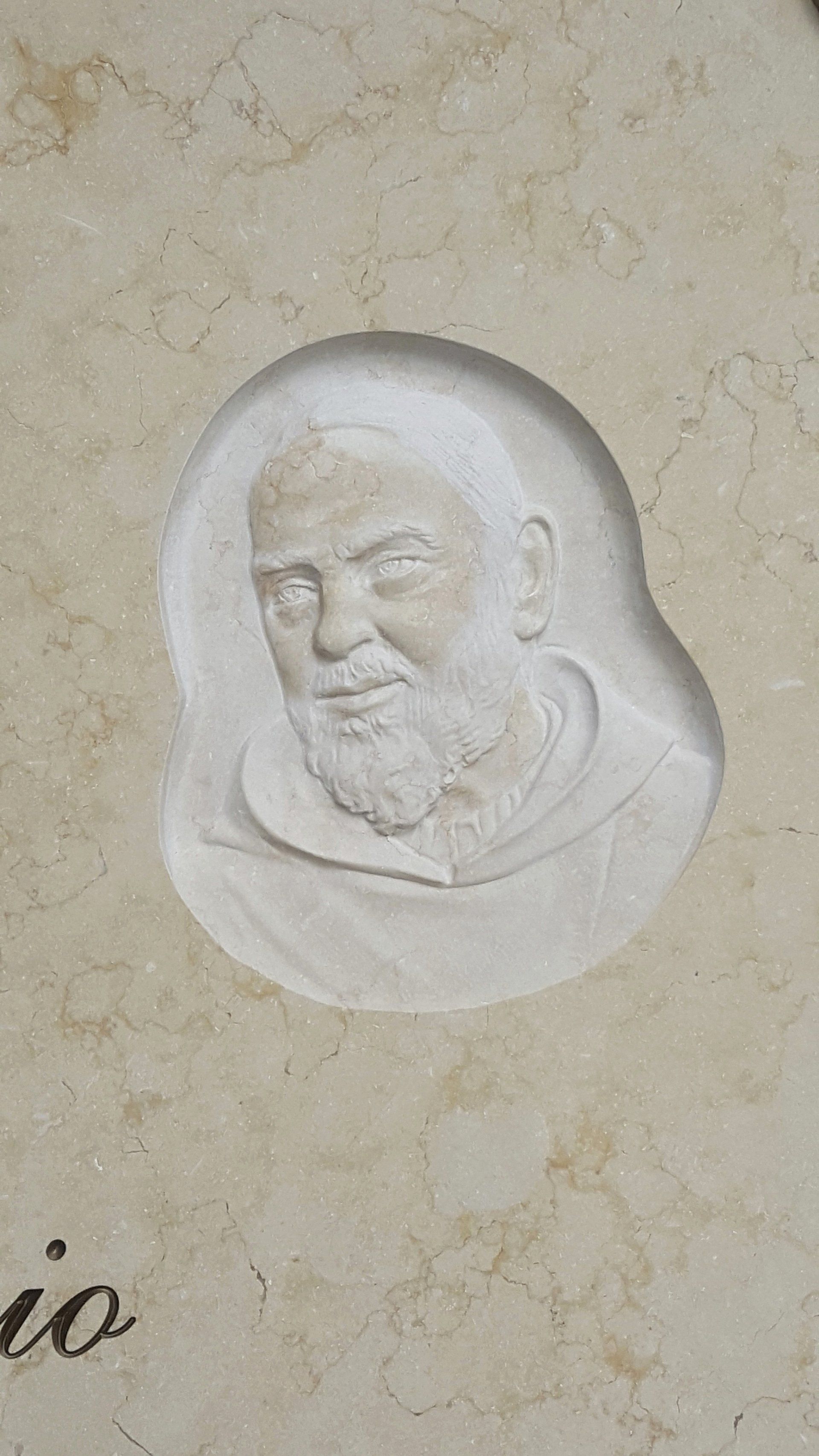 bassorilievo su marmo beige rappresentante padre pio
