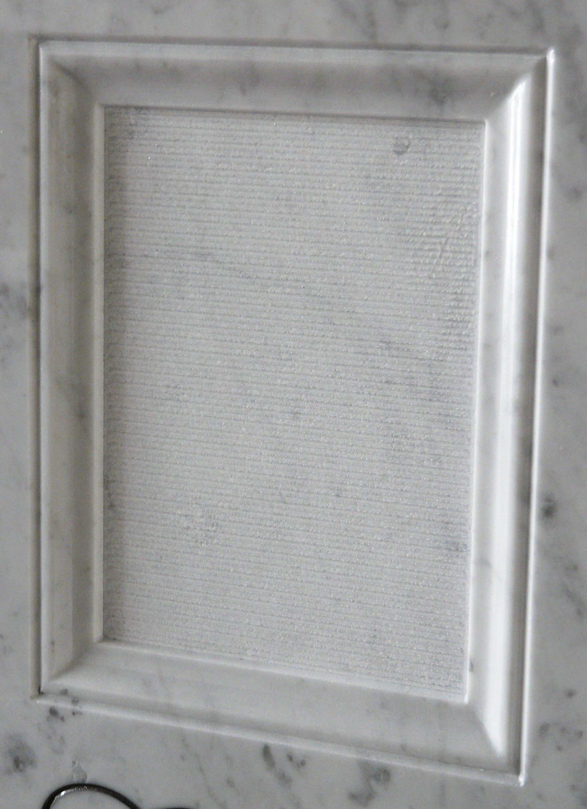 bassorilievo su marmo bianco rappresentante una cornice