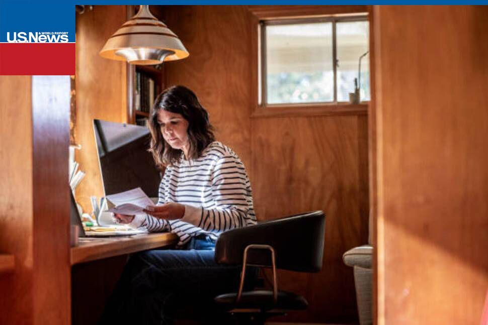 Reviewing paperwork in a home office, reflecting last-minute tax planning & financial decisions.