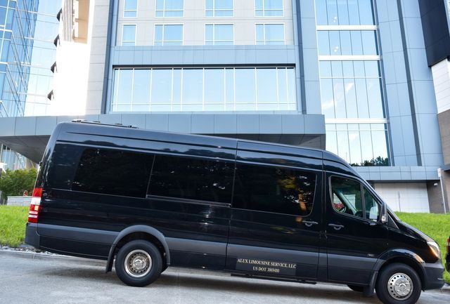 A black van is parked in front of a building.