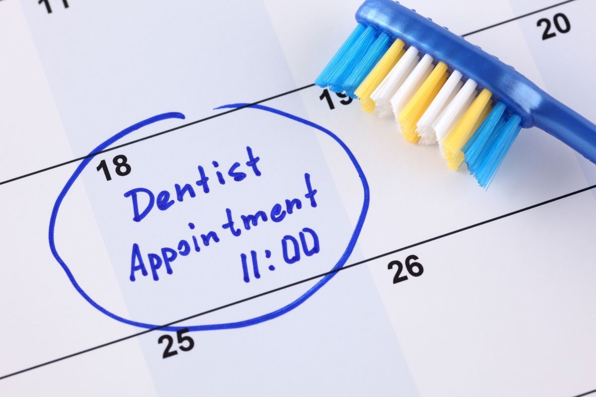 A blue toothbrush is on a calendar that says dentist appointment 11:00