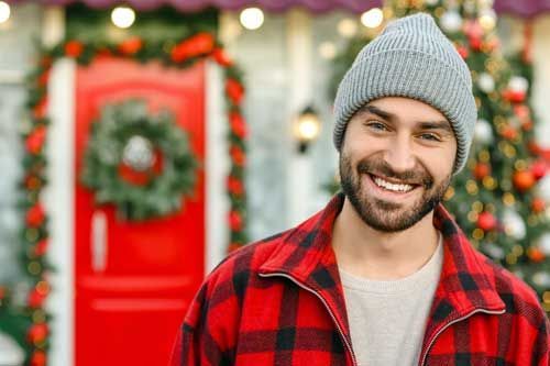 A man wearing a santa hat and a red shirt is smiling.