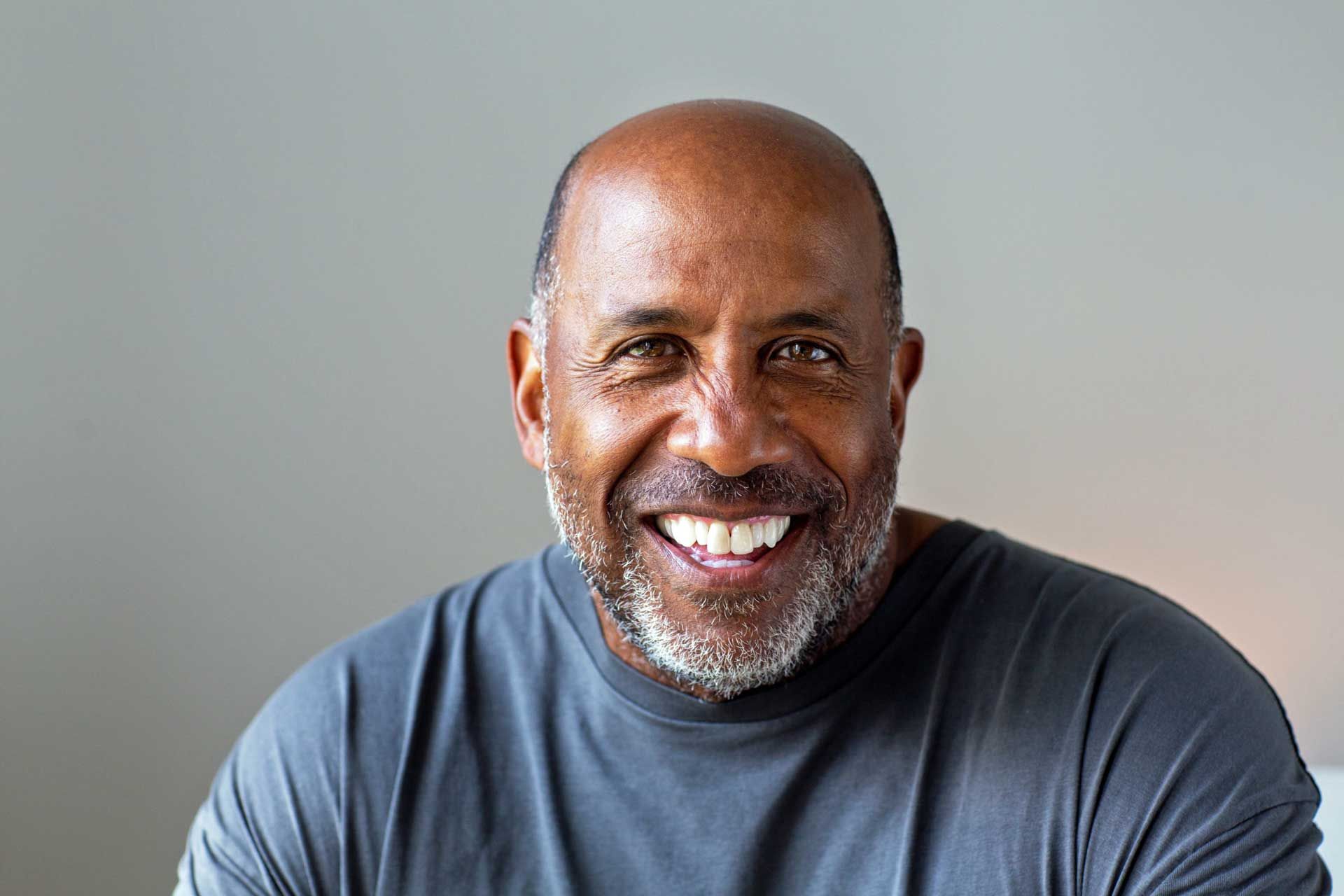 A photo of a bald man with a beard smiling for the camera.