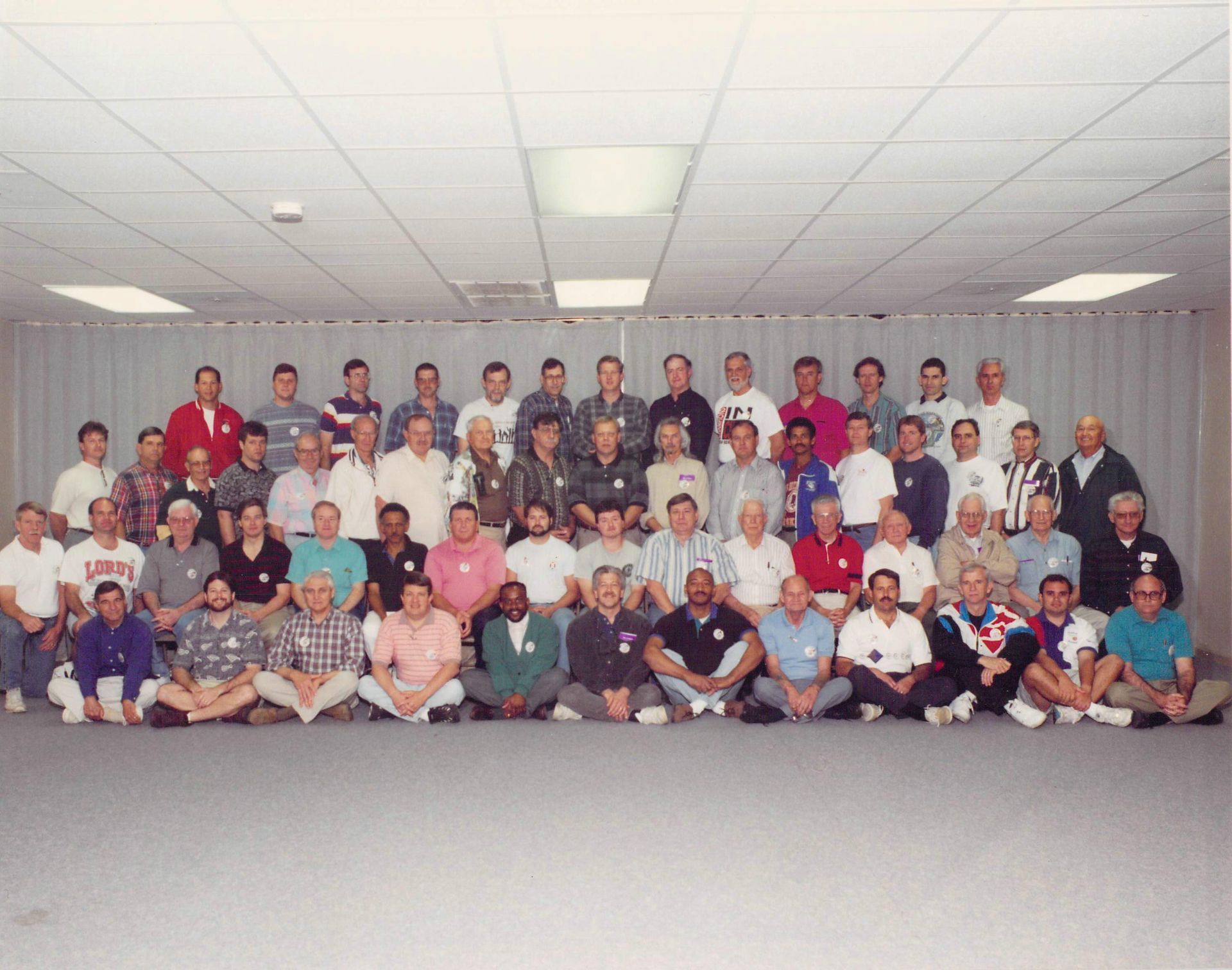 A large group of men are posing for a picture and one of them is wearing a louisiana shirt