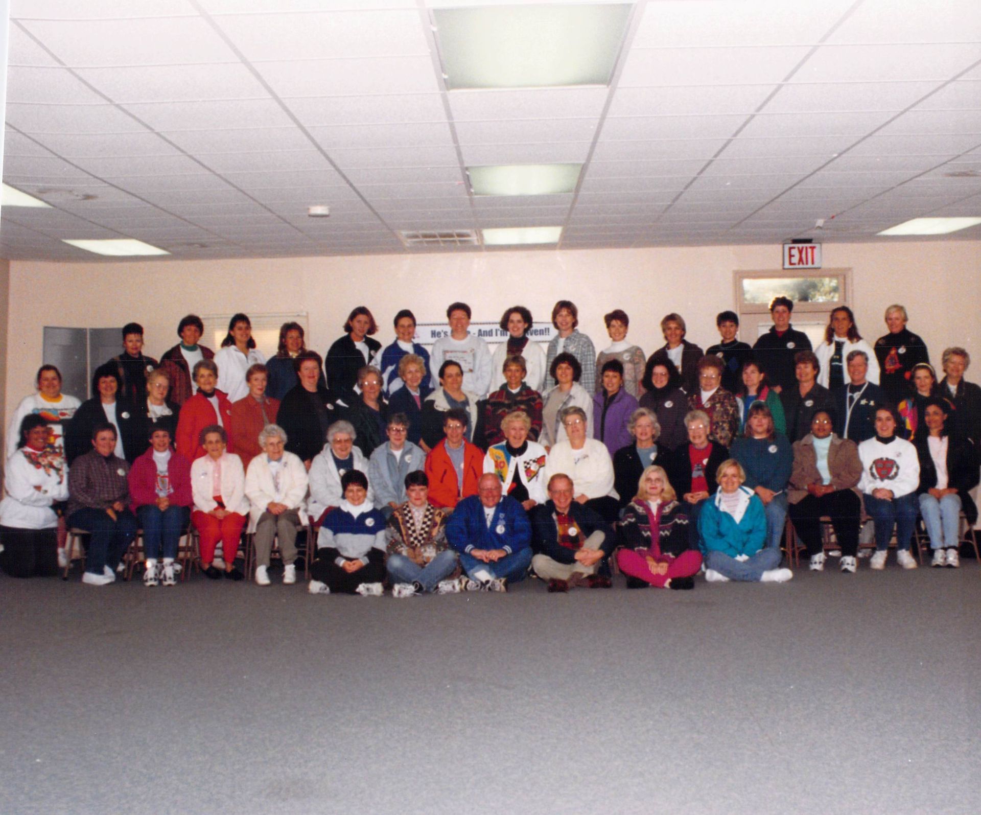 A large group of people are posing for a picture in a room