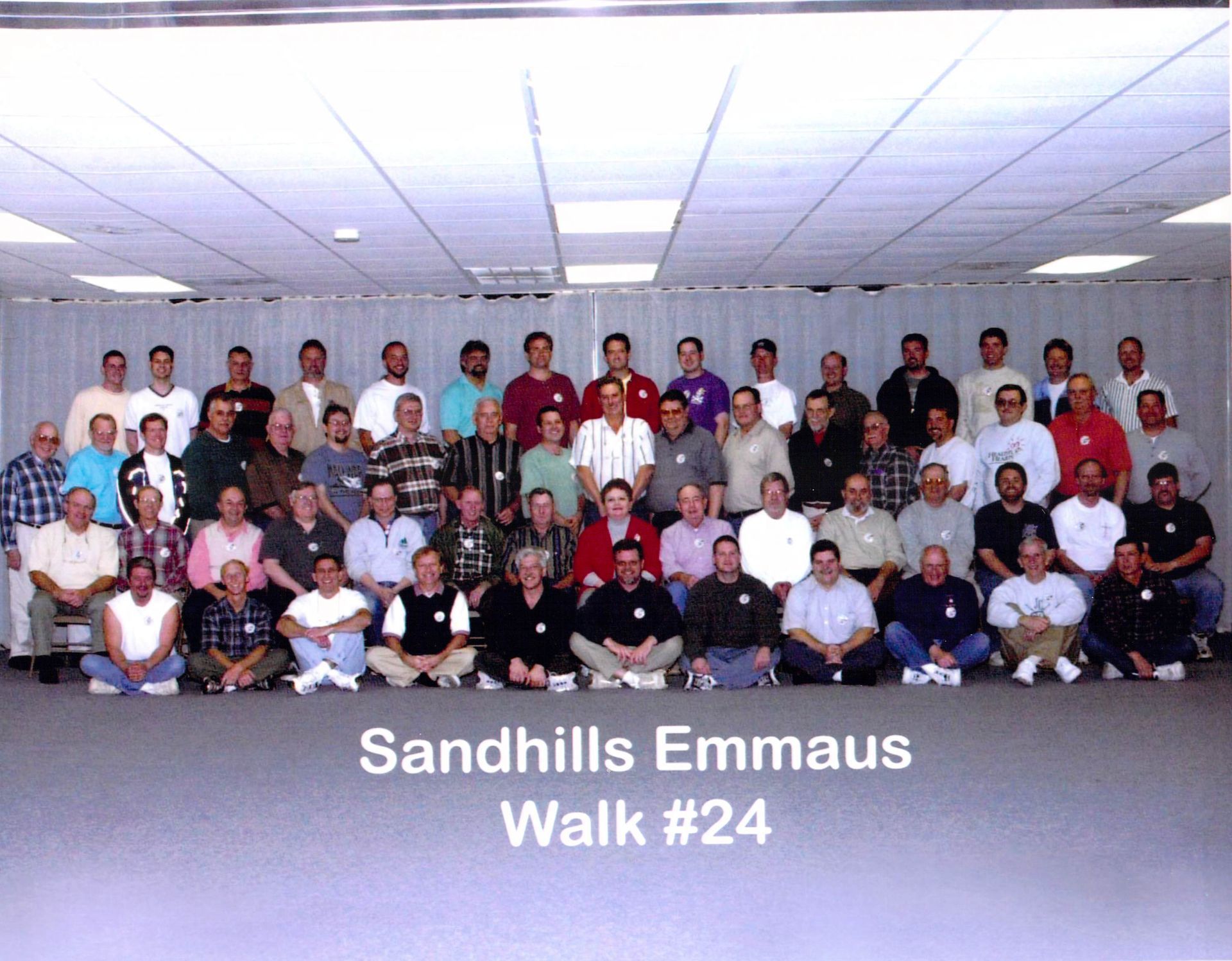 A large group of men are posing for a photo with the caption sandhills emmaus walk # 24