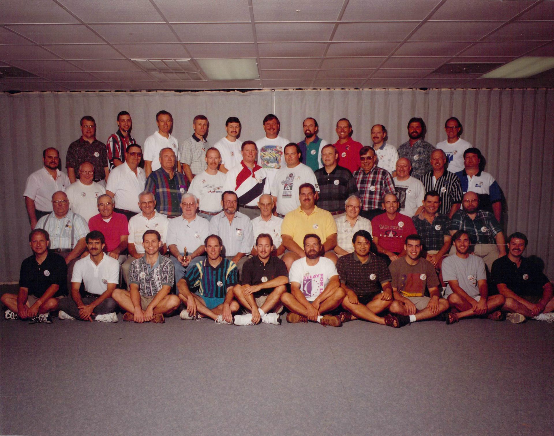 A large group of people are posing for a picture and one of them is wearing a shirt that says 10
