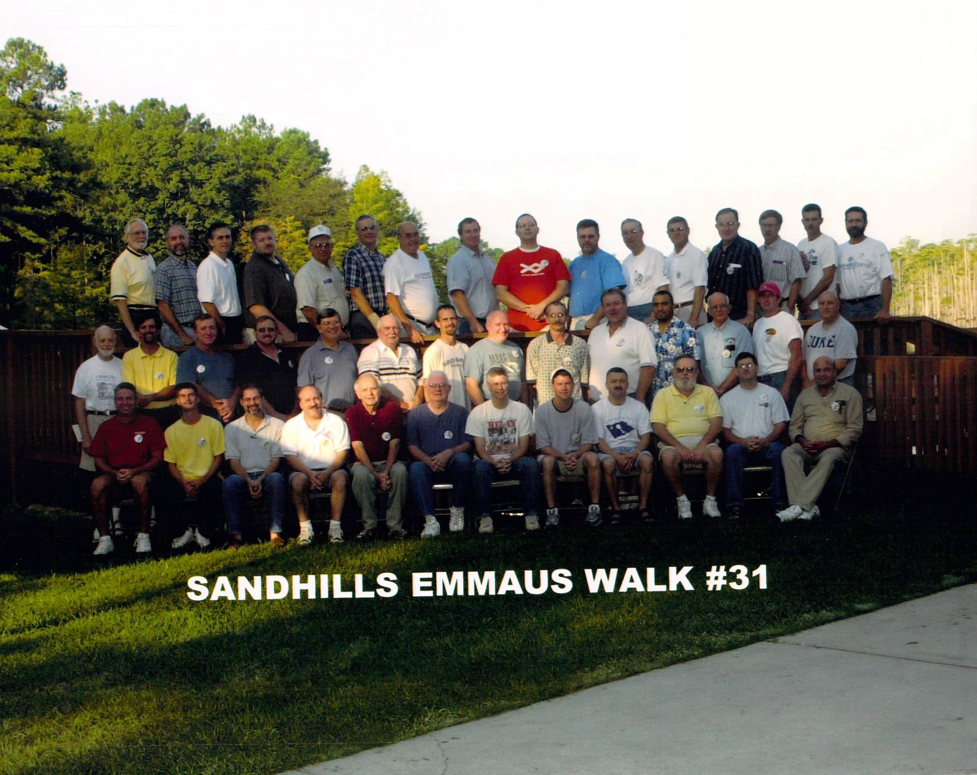 A group of men are posing for a photo and the caption says sandhills emmaus walk # 31