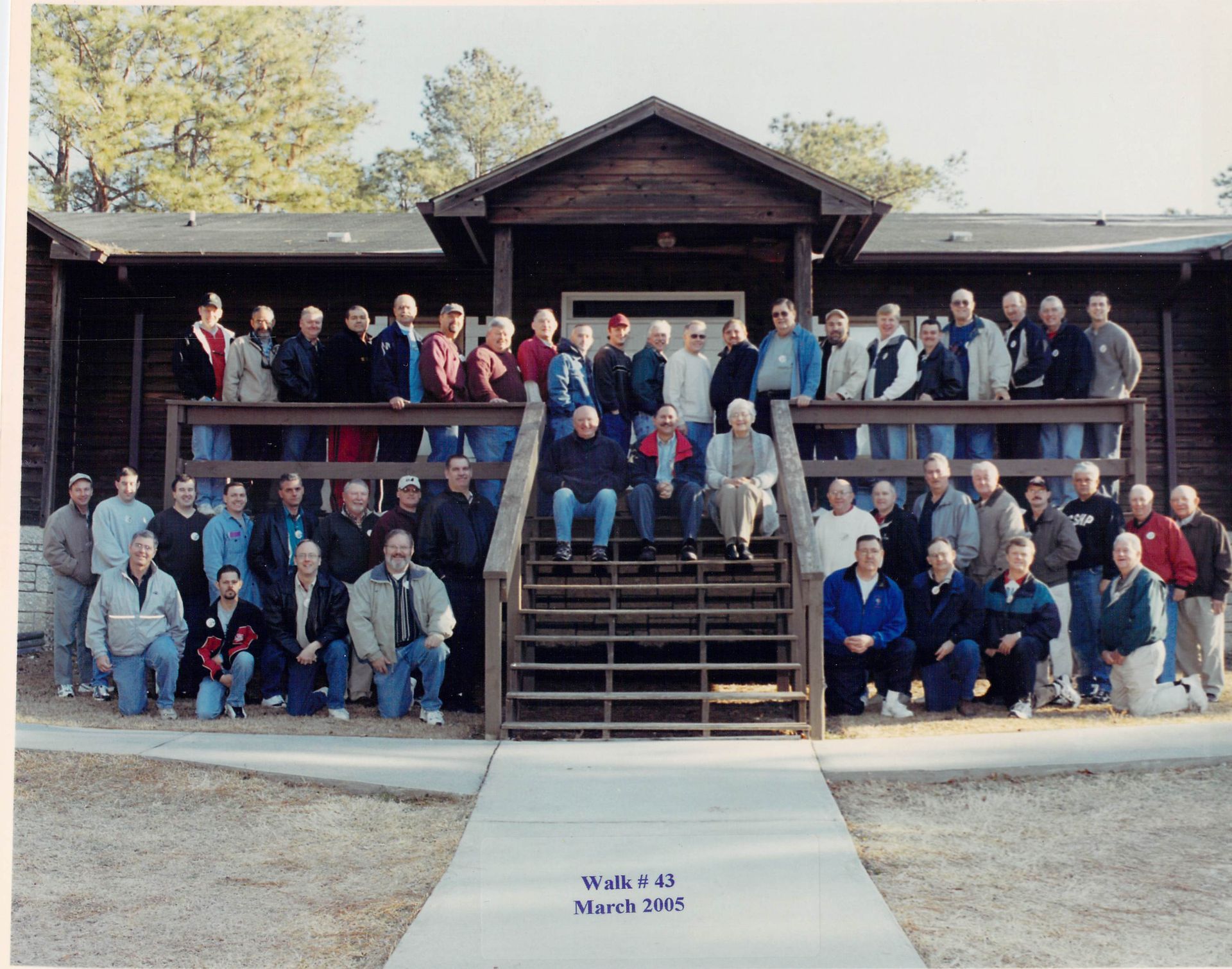 A group of people are posing for a picture in front of a building that says ' wild ' on it