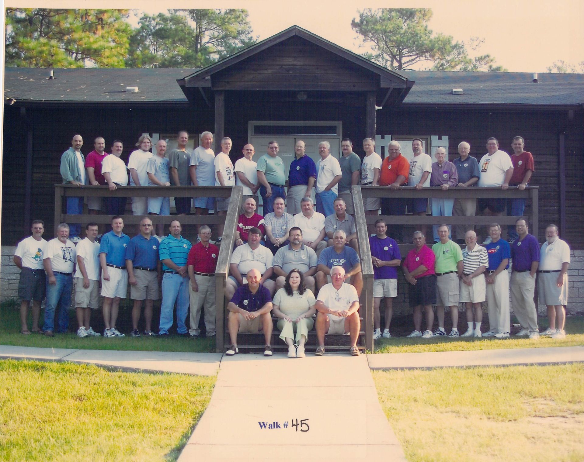 A group of people standing in front of a building with the number 45 on the sidewalk