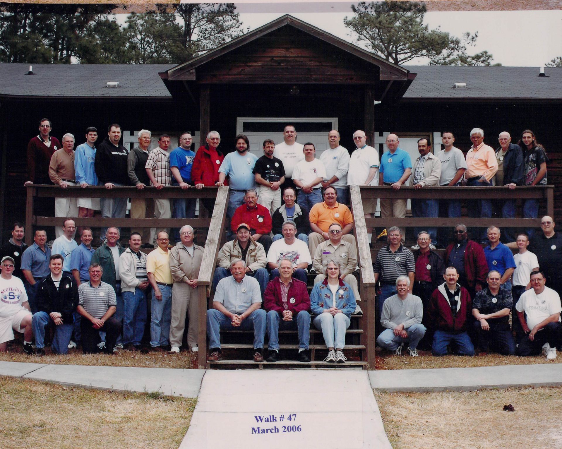 A large group of people are posing for a picture in front of a building